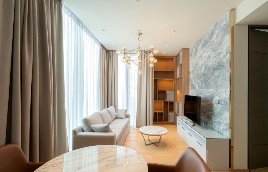 Living room and dining area in a modern apartment with contemporary furniture and ample natural light.